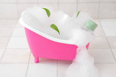 Hafif fayanslı köpüklü ve kozmetik ürünlü küçük küvet