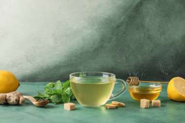 Bir bardak zencefilli çay ve yeşil masada bal.