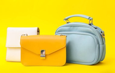 Sarı arka planda farklı tarz çantalar.