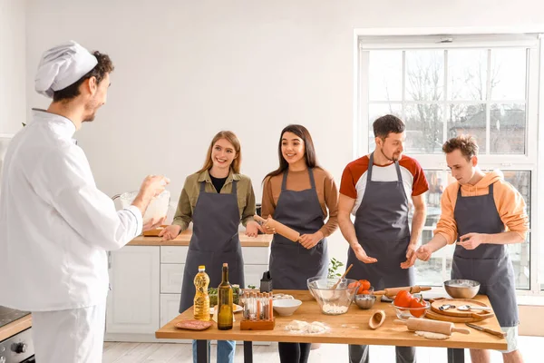 Grupa Młodych Ludzi Włoskim Kucharzem Przygotowującym Pizzę Podczas Lekcji Gotowania — Zdjęcie stockowe
