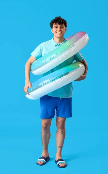 Junger Mann Mit Aufblasbaren Ringen Auf Blauem Hintergrund — Stockfoto