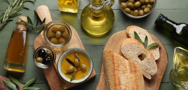 Sağlıklı zeytinyağı ve yeşil ahşap arka planda taze ekmek.