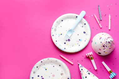 Kağıt tek kullanımlık sofra takımı ve pembe arka planda farklı parti dekorasyonu