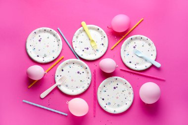 Masa ayarları kağıt sofra takımı ve pembe arka planda balonlar