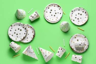 Yeşil arkaplanda kağıt tek kullanımlık sofra takımı ve parti dekorundan yapılmış çerçeve