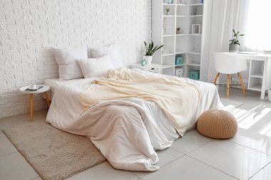 Konforlu yatağı, raf ünitesi ve pencerenin yanındaki masası olan hafif çocukların yatak odası.