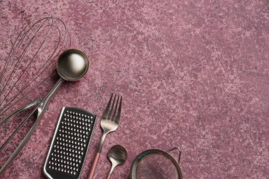 Mor arka planda farklı mutfak aletleri