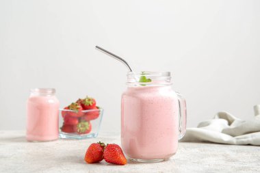 Masada bir kavanoz lezzetli çilekli smoothie var.