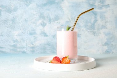 Masada bir bardak lezzetli çilekli smoothie.