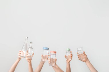 Arka planda soğuk su şişeleri olan kadın eller.