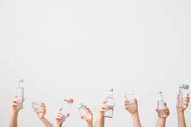 Şişeli kadın eller ve arka planda soğuk su bardakları.