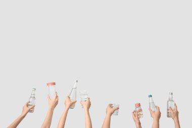 Şişeli kadın eller ve arka planda soğuk su bardakları.