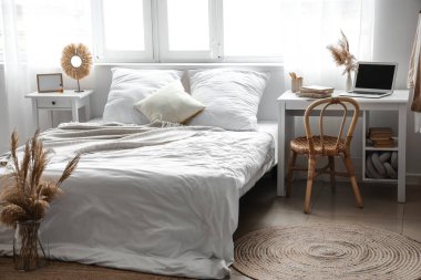 Modern dizüstü bilgisayarlı, rahat yatak ve pencereli, hafif çocukların yatak odasının içi.