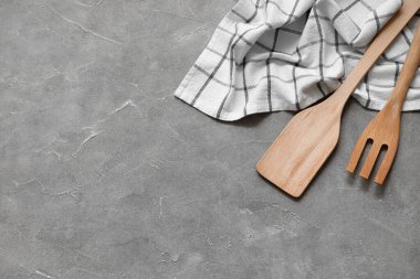 Tahta spatula, çatal ve peçete gri arka planda.