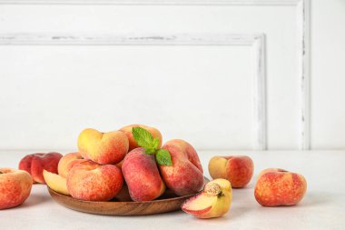 Tahta tabak, şeftalili ve nane şekerli beyaz arka plan