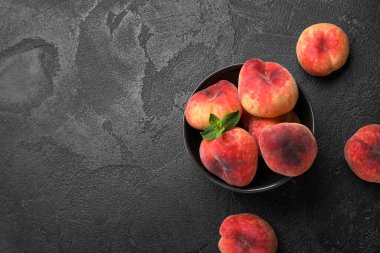 Tatlı incir şeftalili kase ve siyah arkaplanda nane.