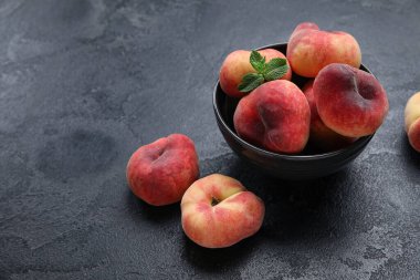 Tatlı incir şeftalili kase ve siyah arkaplanda nane.