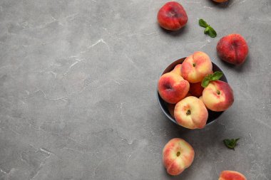 Tatlı incir şeftalili kase ve gri arka planda nane şekeri.