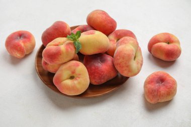 Tahta tabak, şeftalili ve nane şekerli beyaz arka plan