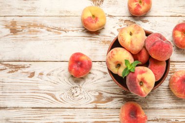 Tatlı incir şeftalili kase ve beyaz ahşap arka planda nane.