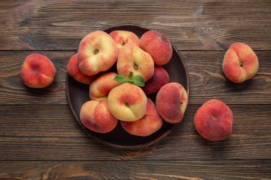 Tatlı incir şeftalili tabak ve ahşap zemin üzerinde nane.