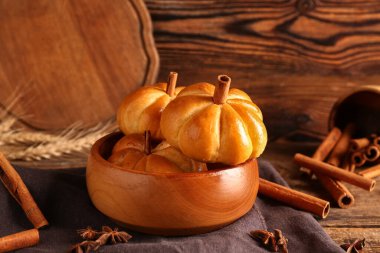 Ahşap arka planda lezzetli balkabağı şekilli çörekler.