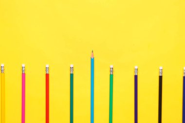 Sarı arkaplanda renkli kalemler grubu