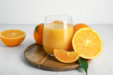 Tahta tahta tahta, beyaz arka planda bir bardak taze portakal suyu.