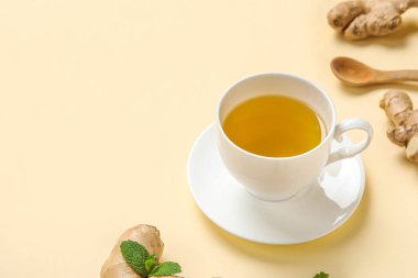 Sarı arkaplanlı bir fincan zencefilli çay.