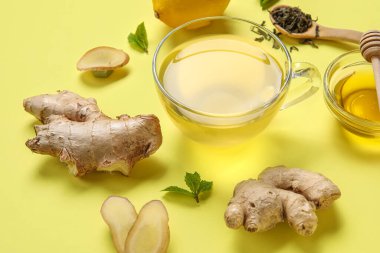 Sarı arka planda bal ve zencefilli çay.