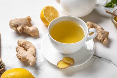 Beyaz arka planda limonlu zencefil çayı.