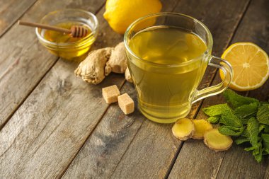 Bir bardak zencefilli çay ve ballı ahşap zemin