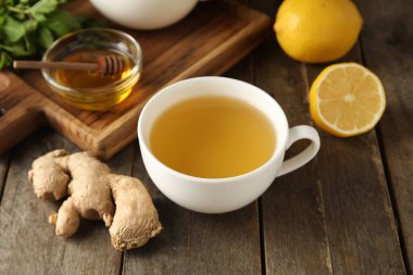 Bir fincan zencefilli çay ve bal, ahşap zemin üzerinde.