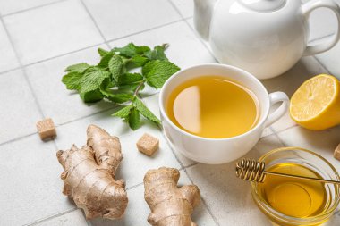 Beyaz fayanslı bir fincan zencefilli çay ve bal.