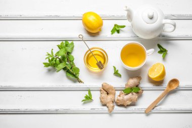 Beyaz arka planda bal ve zencefilli çay.