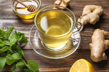 Bir bardak zencefilli çay ve ballı ahşap zemin