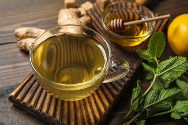 Bir bardak zencefilli çay ve ballı ahşap zemin