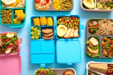 Mavi arka planda farklı lezzetli yemekleri olan bir sürü beslenme çantası.