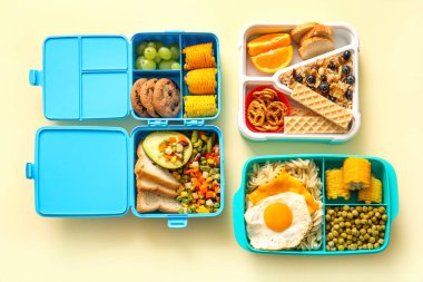 Açık sarı arka planda farklı lezzetli yemekleri olan beslenme çantaları.