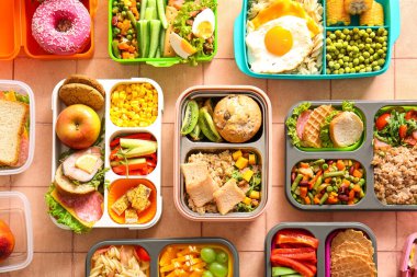 Pembe fayanslı farklı lezzetli yemekleri olan bir sürü beslenme çantası.