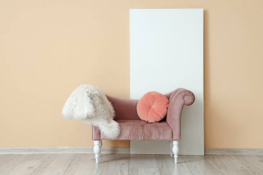 Yastıklı şık koltuk ve bej duvarın yanında kürk halı.