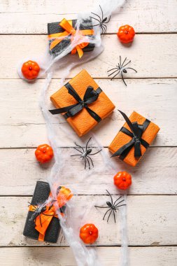 Ahşap arka planda Cadılar Bayramı süslemeleri olan hediye kutuları