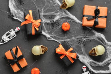 Grunge siyah arka planda Cadılar Bayramı süslemeleri olan hediye kutuları