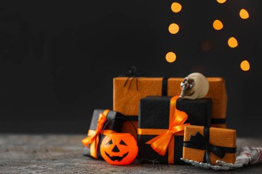 Bulanık ışıklara karşı grunge masasında Cadılar Bayramı süslemeleri olan hediye kutuları