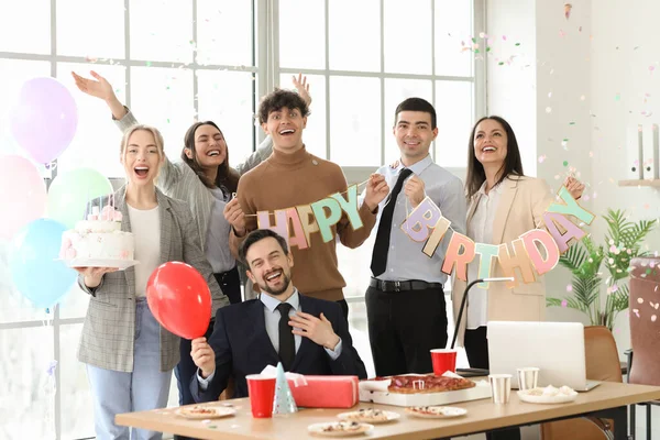 Group of business people at birthday party in office