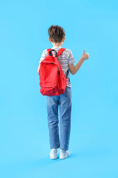 Okul Çantalı Küçük Çocuk Mavi Arka Planda Baş Parmağını Gösteriyor — Stok fotoğraf