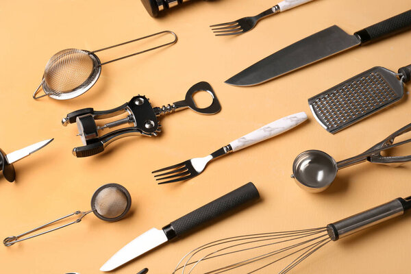 Different kitchen utensils on yellow background