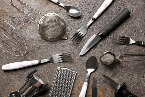 Different kitchen utensils on brown background