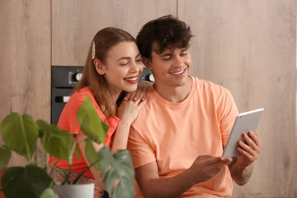 Young couple with tablet computer shopping online in kitchen