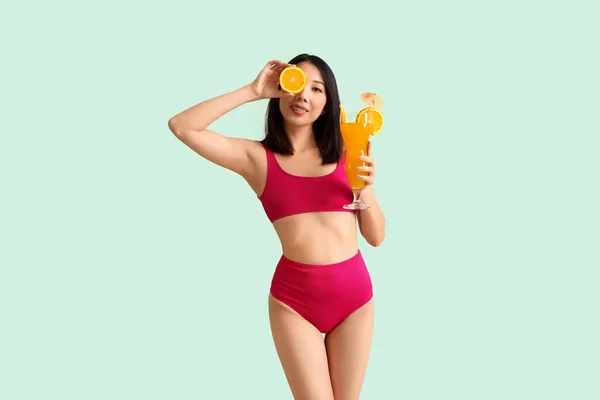 Krásná Asijská Žena Plavkách Oranžovým Koktejlem Světle Barevném Pozadí — Stock fotografie